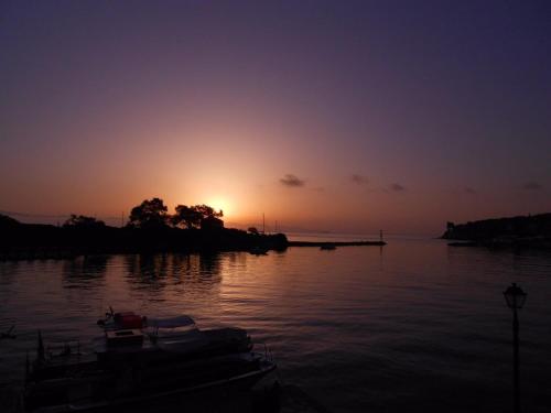 a sunset over a body of water with boats at Sea Front Suite "SEA TALES" in Gaios