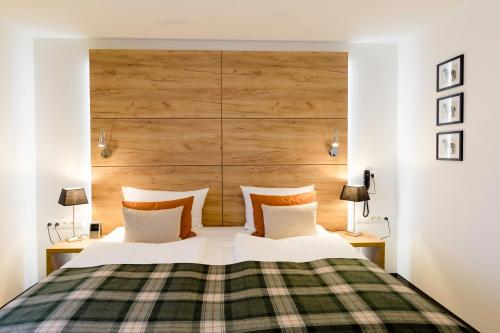 a bedroom with a bed with a wooden headboard at Hotel Restaurant Zwergschlösschen in Gera