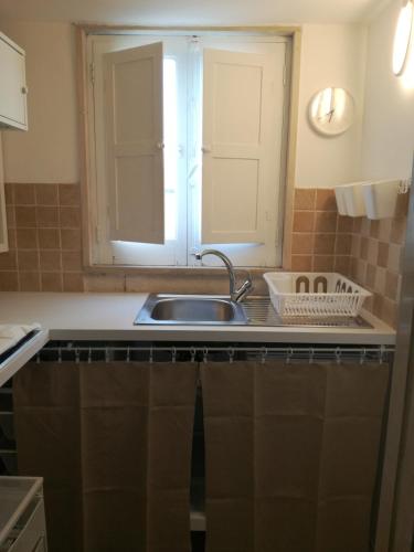 eine Küchentheke mit einem Waschbecken und einem Fenster in der Unterkunft Numero 21 in Andria
