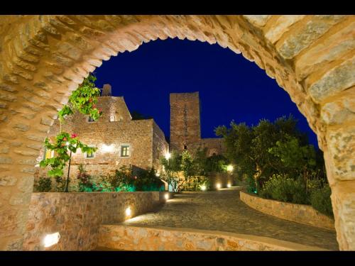 a view of a building from an archway at night at Pandora in Pirgos Dhirou