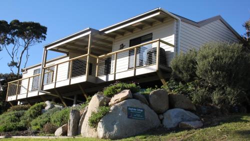 a house sitting on top of a rock at KINGFISHER COTTAGE Beachfront at the Binalong Bay in Binalong Bay