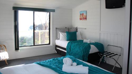 a bedroom with two beds and a window at KINGFISHER COTTAGE Beachfront at the Binalong Bay in Binalong Bay