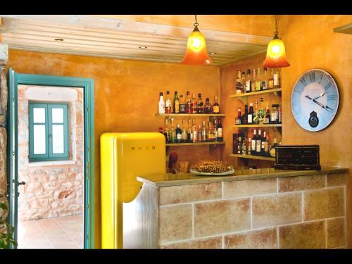 a bar with a yellow refrigerator and a clock at Pandora in Pirgos Dhirou