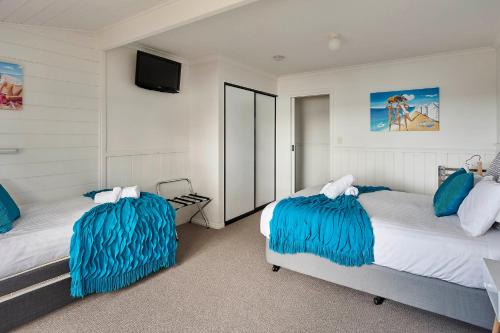 A bed or beds in a room at KINGFISHER COTTAGE Beachfront at the Binalong Bay