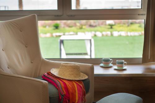 a chair with a basket on top of it next to a window at Herods Dead Sea – A Premium Collection by Fattal Hotels in Neve Zohar