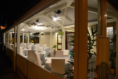 a restaurant with white tables and white chairs at Residenza Mordini in La Maddalena