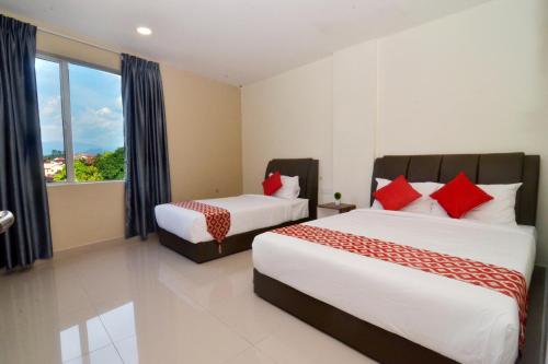 a hotel room with two beds and a window at Hotel Raub Agro in Raub