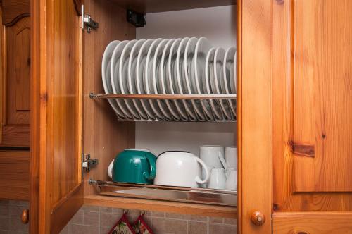 a cupboard with plates and mugs in it at Case Vacanza Torre Canne in Torre Canne