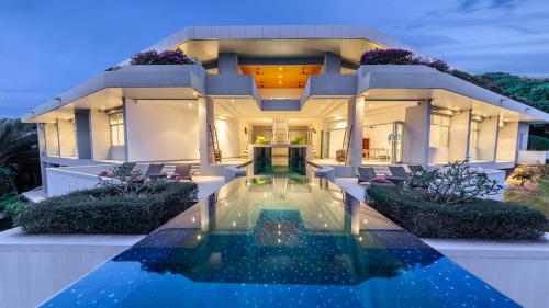 a house with a swimming pool in front of it at Villa Leelawadee in Por Bay