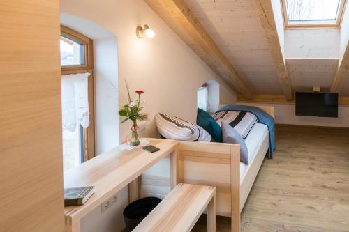 ein kleines Haus mit einem Bett und einem Schreibtisch in der Unterkunft Pension Baumgartner in Rott am Inn