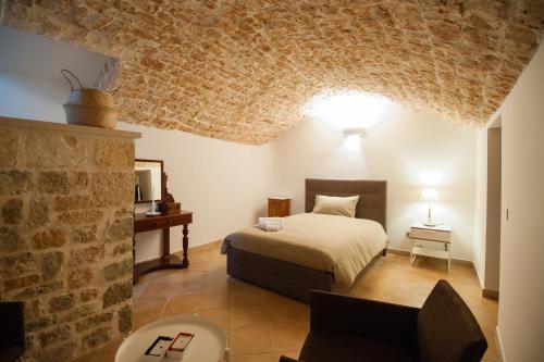 - une chambre avec un lit et un mur en pierre dans l'établissement Pietre in Aria, à Noci