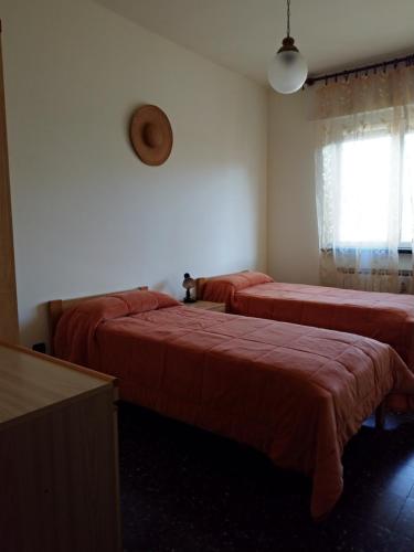 a room with two beds with red sheets and a window at Via della Chiusa 101 in Sestri Levante