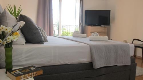 a bedroom with a large white bed with a television at Ogreca in Skradin