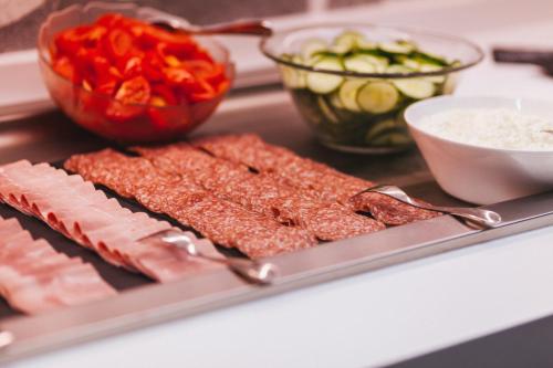 a tray of food with meat and vegetables on a counter at ibis Styles Basel City in Basel