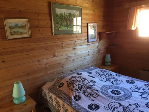 une chambre avec un lit dans une cabane en bois dans l'établissement Las Aires, à Casteil