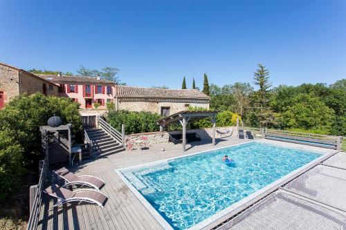 - une grande piscine sur une terrasse en bois à côté d'une maison dans l'établissement Domaine Anguyales, à Montmaur