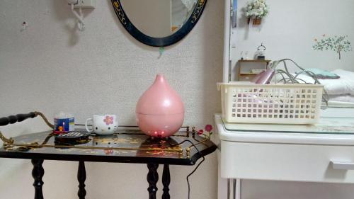 a table with a pink vase on top of it at Miyako in Hachioji