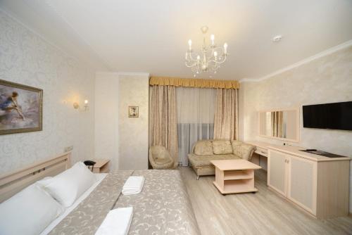 um quarto de hotel com uma cama, um sofá e uma televisão em Angelina Hotel em Moscou