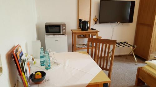 a room with a white table and a television at Hotel Goldflair am Rathaus in Korbach