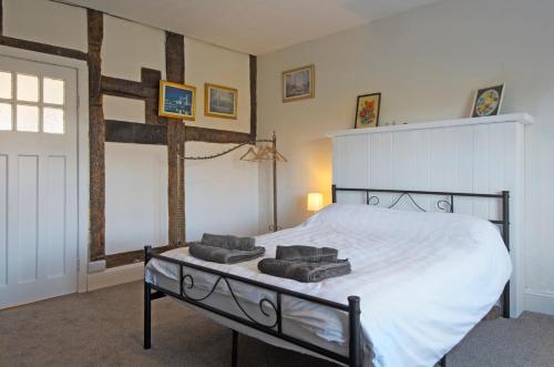 a bedroom with a bed with two towels on it at The Old Farm House in Hereford