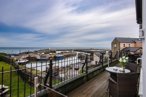 a balcony with a view of a marina at The Bamburgh Castle Inn - The Inn Collection Group in Seahouses