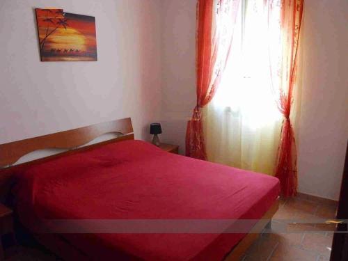 レウカにあるCasa Vacanze salentoのベッドルーム1室(赤いベッド1台、窓付)