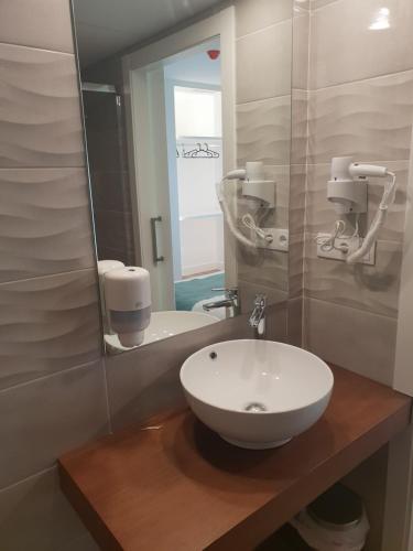 uma casa de banho com um lavatório e um espelho em Hostal Cabañas em Carboneras de Guadazaón