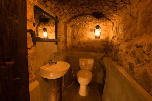 a bathroom with a sink and a toilet in a cave at Venture Camps in Kandy