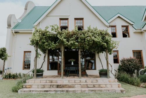 a white house with a green roof at Cana Vineyard Guesthouse in Paarl