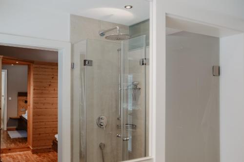 a bathroom with a shower with a glass door at Landhaus Alpengruss in Kössen