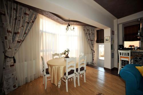 a dining room with a table and chairs at Classic Apartment in Braşov