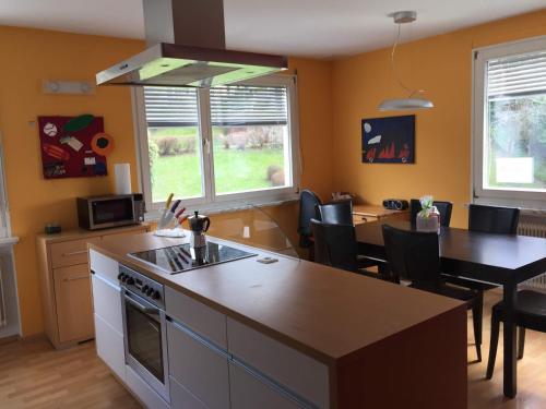 - une cuisine et une salle à manger avec une cuisinière et une table dans l'établissement Ferienwohnung Viers, à Bregenz