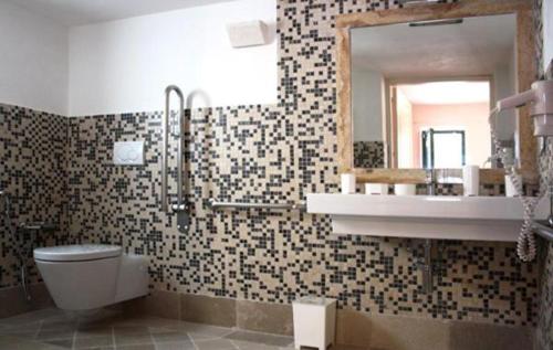 a bathroom with a toilet and a sink and a mirror at B&B Margherita in Ostuni