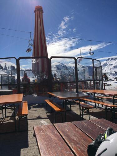 a patio with tables and an umbrella and mountains at Obereggen - Anna in Eggen