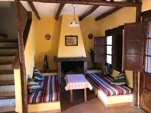 a living room with two couches and a fireplace at Casa Rural Albahaca in Jimera de Líbar