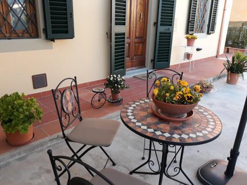 a patio with chairs and a table with a pot of flowers at Villa Monica in Pistoia