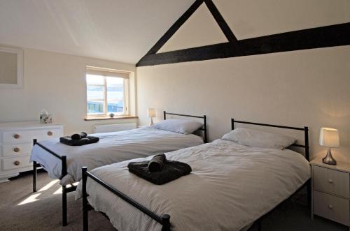 ein Schlafzimmer mit 2 Betten und Handtüchern darauf in der Unterkunft The Mill at Rose Villa Farm in Hereford