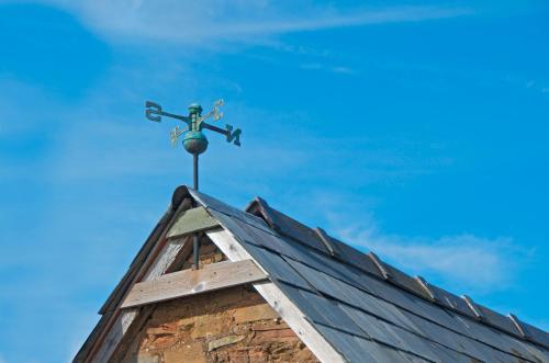 a weather vane on the roof of a building at The Mill at Rose Villa Farm in Hereford
