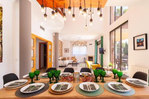 a dining room with a wooden table with green dishes on it at VILLA WINE EXPERIENCE Salou Center - SPA & Wine in Salou