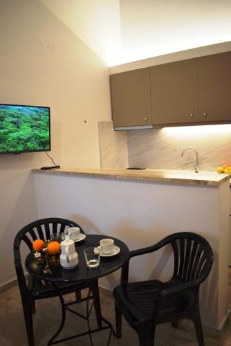 a kitchen with a table and two chairs and a television at Studio Candia in Kandia