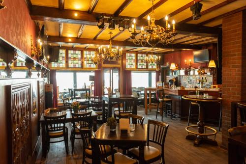 ルールモントにあるホテル エン グランド カフェ ド ポーのテーブルと椅子のあるレストラン、バー