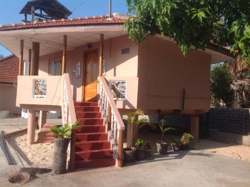 a small house with a staircase in front of it at pesalai plvillas in Pesalai