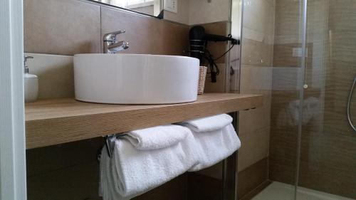 a bathroom with a sink and towels on a counter at Appartamento Sant'Anna I in Salò