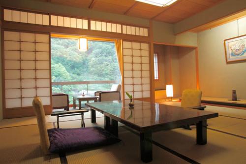 a room with a table and chairs and a window at Enraku in Kurobe