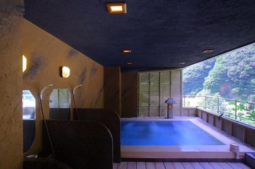 a large swimming pool in a room with a large window at Enraku in Kurobe