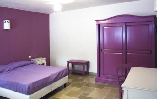 una camera con letto viola e armadietto viola di B&B Margherita a Ostuni