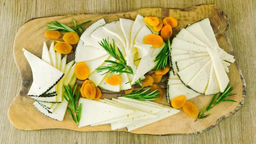 a plate of cheese and vegetables on a table at Club Maspalomas Suites & Spa - Adults Only in Maspalomas
