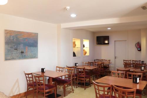 a dining room with wooden tables and chairs at Hotel Maycar in A Coruña