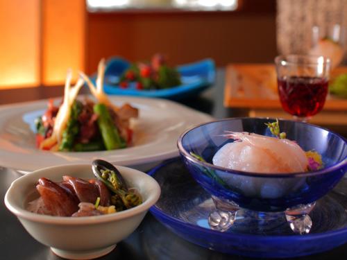a table with two plates of food and a bowl of food at Enraku in Kurobe