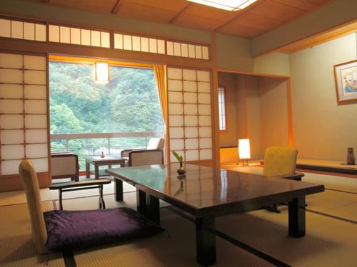 a room with a table and chairs and a window at Enraku in Kurobe